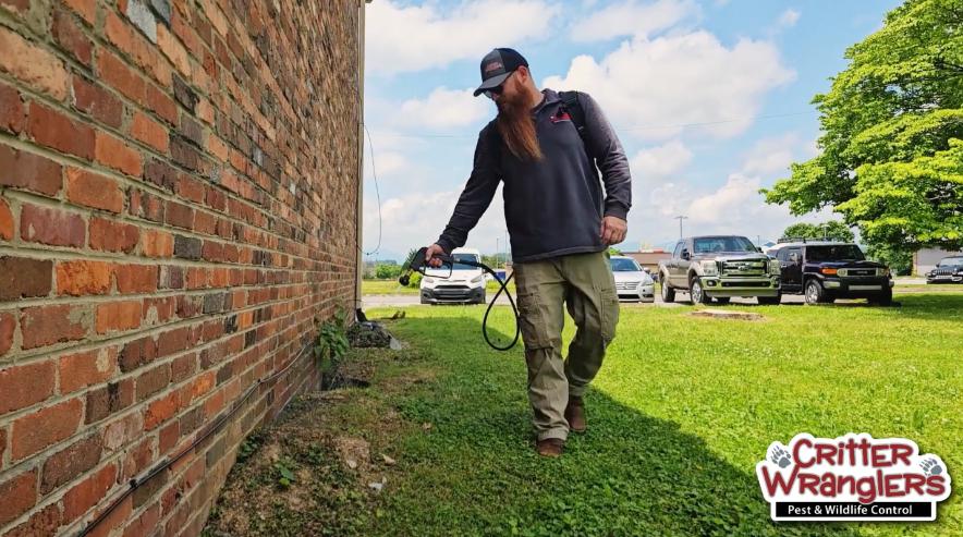 Critter Wranglers technician performing exterior pest treatment